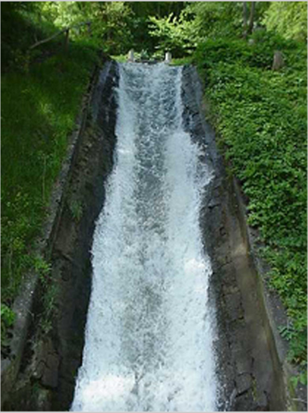L'eau dévale dans un couloir entre le chemin de halage et la route